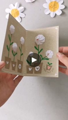 someone is holding up a card with flowers on it