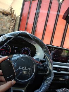 a person driving a car with a steering wheel cover over their head and the dashboard