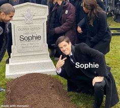 a group of people standing around a grave with the words sophiie written on it