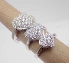 "This pave diamond heart shape ring is hand made in 18k white gold. There are 36 Pave set side diamonds totaling .76Cts, approximately 3/4 Carat The diamonds are VS clarity and G color range. We make all our own jewelry and focus on quality and durability. The ring is currently a size 6.25 you will be able to return it within the listed time frame for any reason at all. It will take 1-2 business days processing time. We can size it any size from 5 to 7 but it would be a FINAL SALE. It will take Fine Jewelry Heart Ring With Pave Setting As Gift, Heart Cut Rings With Pave Setting For Gift, Valentine's Day Heart Ring With Pave Setting As Gift, Heart Ring With Pave Setting As Gift, Heart Cut Ring With Pave Setting As Gift, Heart Cut Hallmarked Diamond Ring Gift, Heart Shaped Diamond Ring With Pave Setting, Diamond Heart Ring With Pave Setting For Valentine's Day, Valentine's Day Diamond Heart Ring With Pave Setting