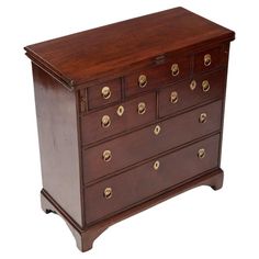 an antique chest of drawers with brass knobs on the top and bottom, in dark wood