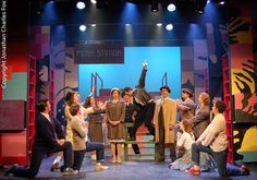 a group of people standing on top of a stage with their hands in the air