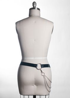 High quality, cyberpunk inspired hip belt in leather or PVC features multiple belt keepers, large o-ring details, and detachable hip chain. Belt is 1.25" wide. Strap end is cut to an angular "sharp" point for that extra industrial edge. Designed to sit at the hip. Color shown is black PVC. Also available in leather and vegan leather. Silver-toned nickel plated steel hardware. All pieces are MADE TO ORDER, standard sizes XS-4XL. If your measurements fall outside these standards or you are unsure Edgy Black Harness With Belt Loops, Edgy Waist Chain For Festivals, Punk Black Chain Belt With Belt Loops, Black Punk Chain Belt With Belt Loops, Black Chain Belt For Festival, Black Chain Belt With Belt Loops For Festivals, Adjustable Edgy Chain Belt, Gothic Industrial, Industrial Goth