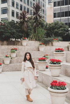 a woman standing in front of some potted flowers