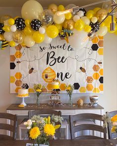 a party with balloons and honeycombs on the wall is ready to be eaten