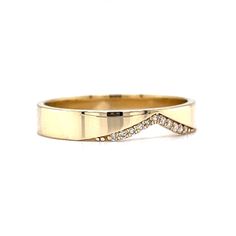 a gold wedding ring with diamonds on the side and an arrow design in the middle