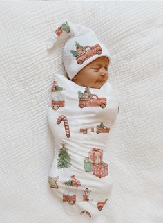 a baby wrapped in a blanket with christmas decorations on it