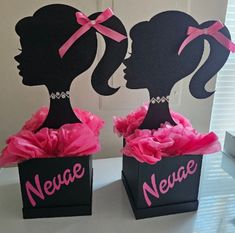 two black boxes with pink bows and the words nevee next to each other