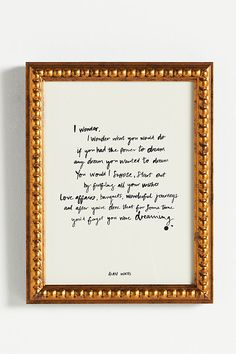 a handwritten poem is framed in an ornate gold frame on the wall above it