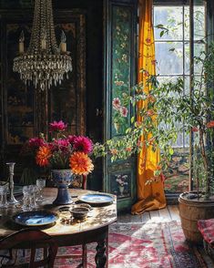 a dining room table with plates and vases on it, in front of an open window