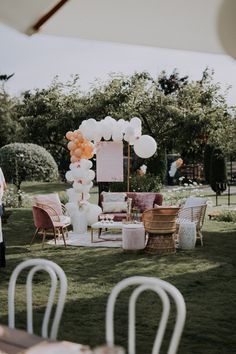 an outdoor wedding setup with balloons and chairs