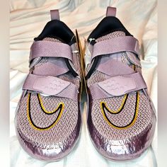 a pair of purple nike shoes with yellow and black accents on the upper part of the shoe