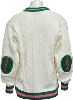 a white sweater with green and pink trims on the sleeves, featuring letters that spell out