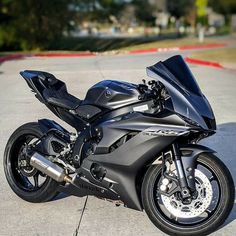 a black motorcycle parked on top of a parking lot