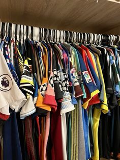 a bunch of shirts are hanging on a rack