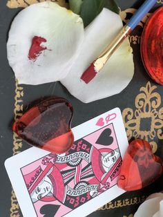 a pair of heart shaped sunglasses sitting on top of a table next to a flower