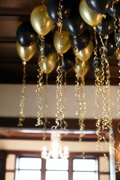 black and gold balloons hanging from the ceiling