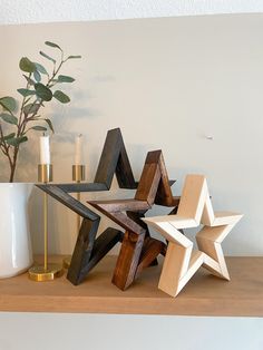 a wooden star sitting on top of a table next to a vase and candle holder