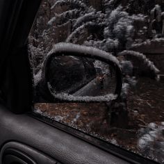 the rear view mirror of a car covered in snow