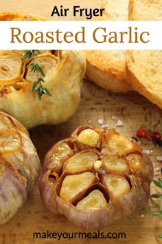 an air fryer roasted garlic on a cutting board with bread and herbs in the background