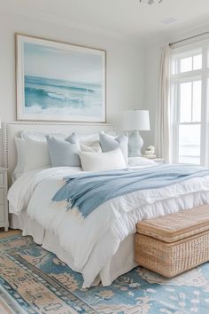 a bedroom with a large bed and blue rug in front of a window that has a painting on the wall above it