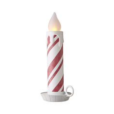 a lit candle with red and white striped candlesticks on it's side