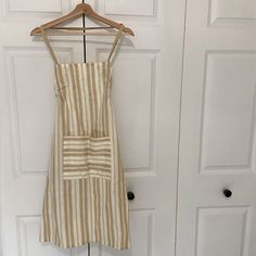 a dress hanging on a hanger in front of two white doors with wooden handles