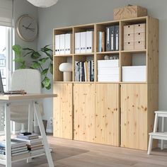 a wooden bookcase in the corner of a room next to a desk and chair