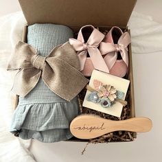 an open box containing baby shoes and a wooden spoon