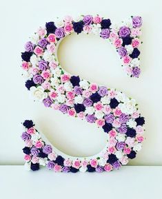 the letter s is made up of flowers and has purple, white, and pink blooms