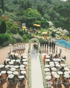 an aerial view of a wedding ceremony with tables and umbrellas