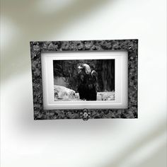 an eagle sitting on top of a white wall next to a black and white frame