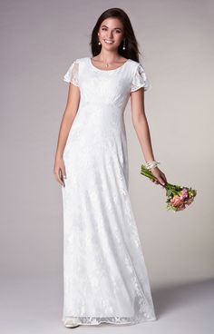 a woman in a white dress holding flowers