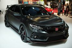 the front end of a gray honda civic type car on display at an auto show