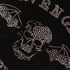 the skull and crossbones on this black shirt are embellished with diamonds