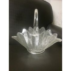 a clear glass bowl sitting on top of a black table next to a leather chair