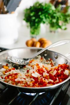 a pan filled with red and white rice on top of a stove