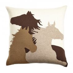 a brown and white pillow with horses on it