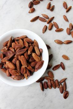 a white bowl filled with almonds on top of a table