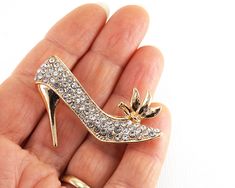 "Get 15% off your order when you buy 2 items :) Large Gold High Heel Shoe Brooch, Elegant Cinderella brooch, Tiny White Rhinestones brooch, Vintage Brooch gold jewelry women This is a beautiful elegant gold high heel brooch, tiny rhinestone crystals are shimmering with any move. Just beautiful! The size is 53mm = 2\" More Fun Exciting Vintage Treasures here: http://www.etsy.com/shop/atVintage" Gold Bling Brooches Gift, Gold Bling Brooches For Gift, Gold Rhinestone Pins For Party, Gold Rhinestone Party Pins, Gold Rhinestone Pins For Wedding, Gold Party Brooches With Bling, Gold Rhinestone Wedding Pins, Gold Wedding Pins With Rhinestones, Gold Jewelry Women