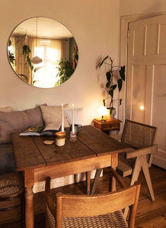 a wooden table sitting under a round mirror