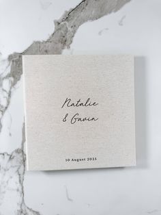 a wedding guest book on top of a marble countertop with the words, natalie and susan written in black ink