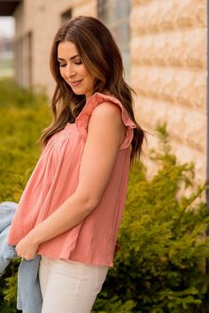 A lightweight and flowy top that looks great on all body shapes and sizes! The gauze texture and ruched detailing at the top gives this tank an extra special look to set it apart from the rest! We love that this can be worn alone in the warmer months or layered up with a cardigan or jacket in the cooler ones and can be dressed up or down with ease! Flowy Smocked Bodice Top With Flutter Sleeves, Pink Tops With Smocked Back And Ruffled Straps, Feminine Sleeveless Blouse With Smocked Back, Spring Flowy Tops With Smocked Back, Chic Smocked Back Tank Top For Spring, Chic Tops With Smocked Back And Ruffled Straps, Flowy Breezy Tops For Day Out, Spring Chic Tank Top With Smocked Back, Chic Spring Tank Top With Smocked Back