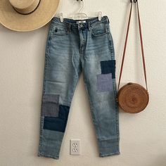 a pair of blue jeans hanging on the wall with a hat and purse next to it