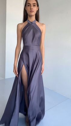 a woman in a long purple dress with high slits on the side and one leg up