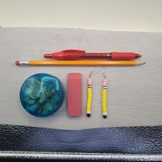 some pens, pencils, and other items are laid out on a table top