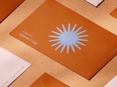 several pieces of paper are laying on top of each other, including one with an orange and blue design