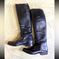 a pair of black leather boots sitting on top of a wooden floor next to each other