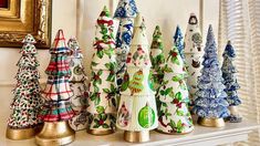 a group of christmas trees sitting on top of a mantle