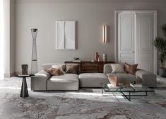 a modern living room with marble flooring and white furniture, including a sectional sofa